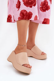 Selentia faux leather wedge sandals in beige, featuring open-toe design and platform, paired with floral print pants.