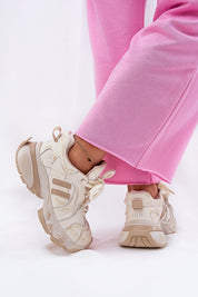 Person wearing pink pants with cream-colored sport shoes featuring thick soles and laces, styled for modern and comfortable fashion.