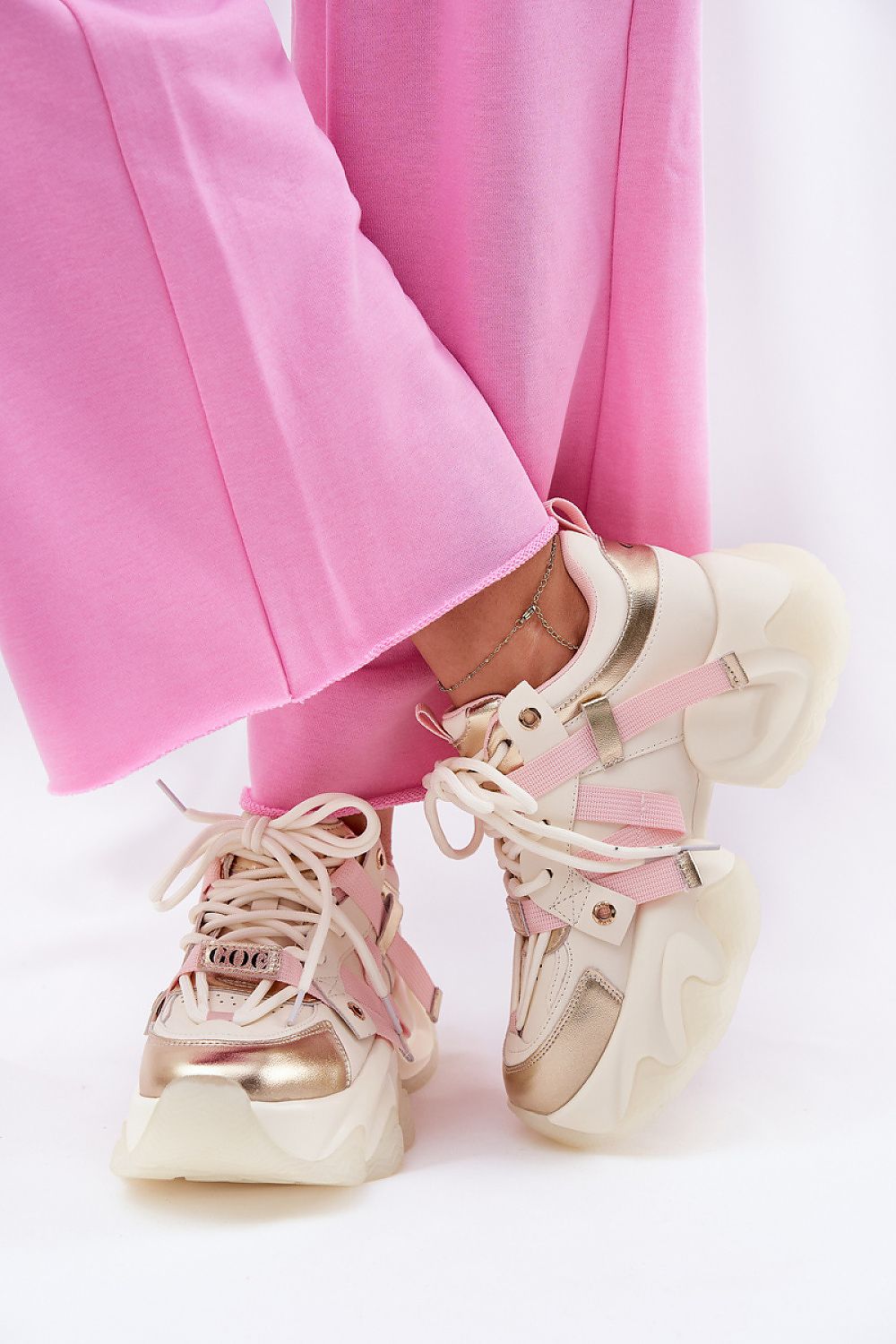 Isalvien double-lace sport shoes with bold platform soles in pink and white leather, paired with pink pants for a stylish look.