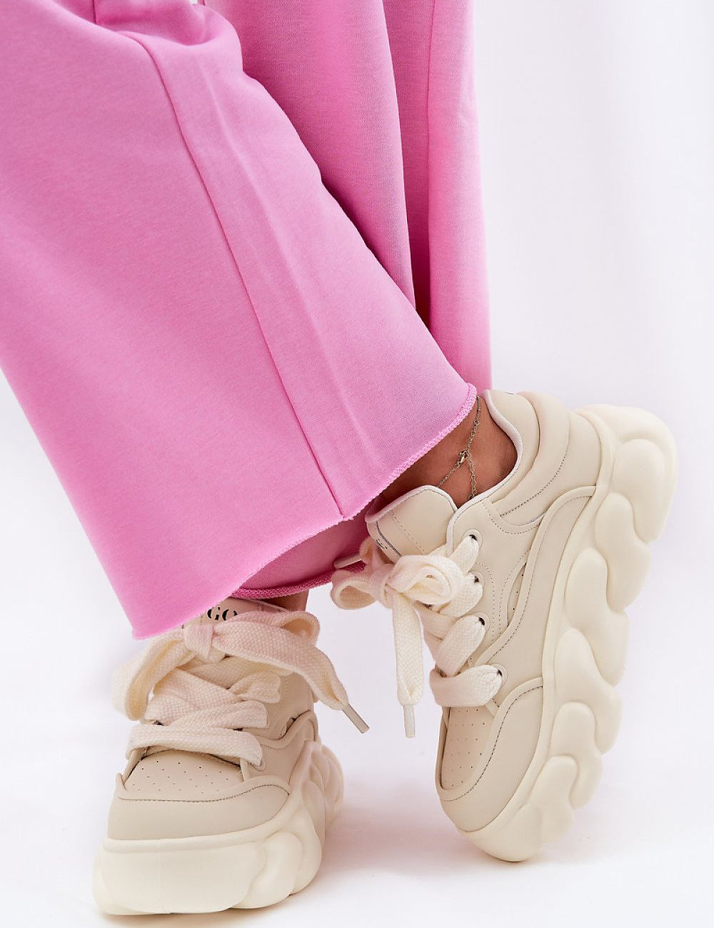 Beige Vernesse Elevated Leather Sport Shoes with thick laces and 5.5 cm platform sole, paired with pink pants for a bold style.