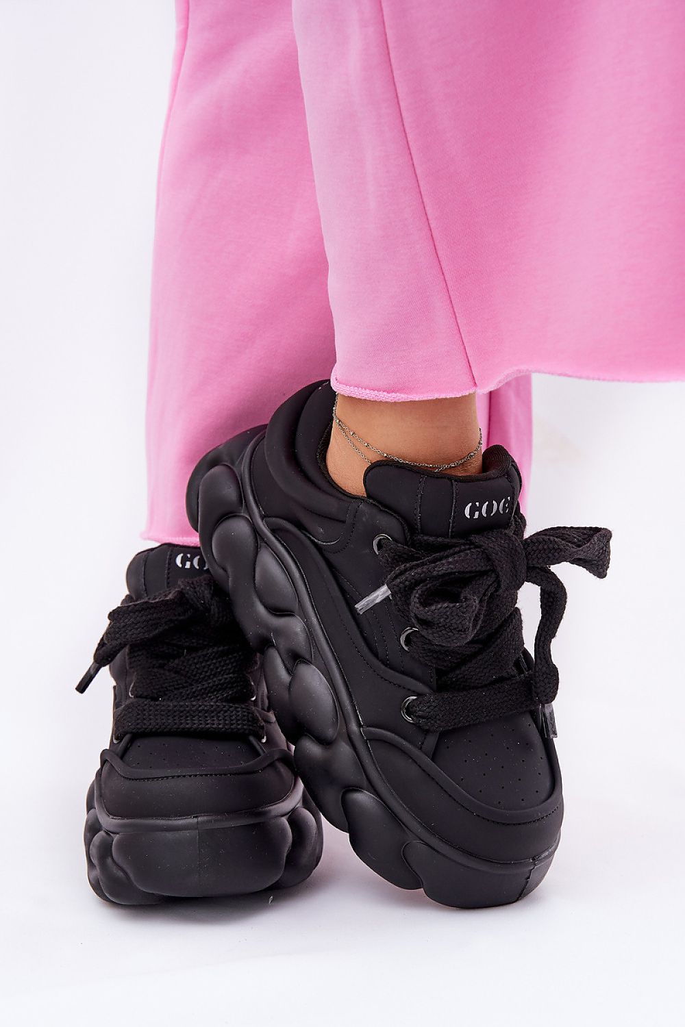 Black Vernesse Elevated Leather Sport Shoes with thick lacing, 5.5 cm platform sole, styled with pink pants for a bold fashion look.