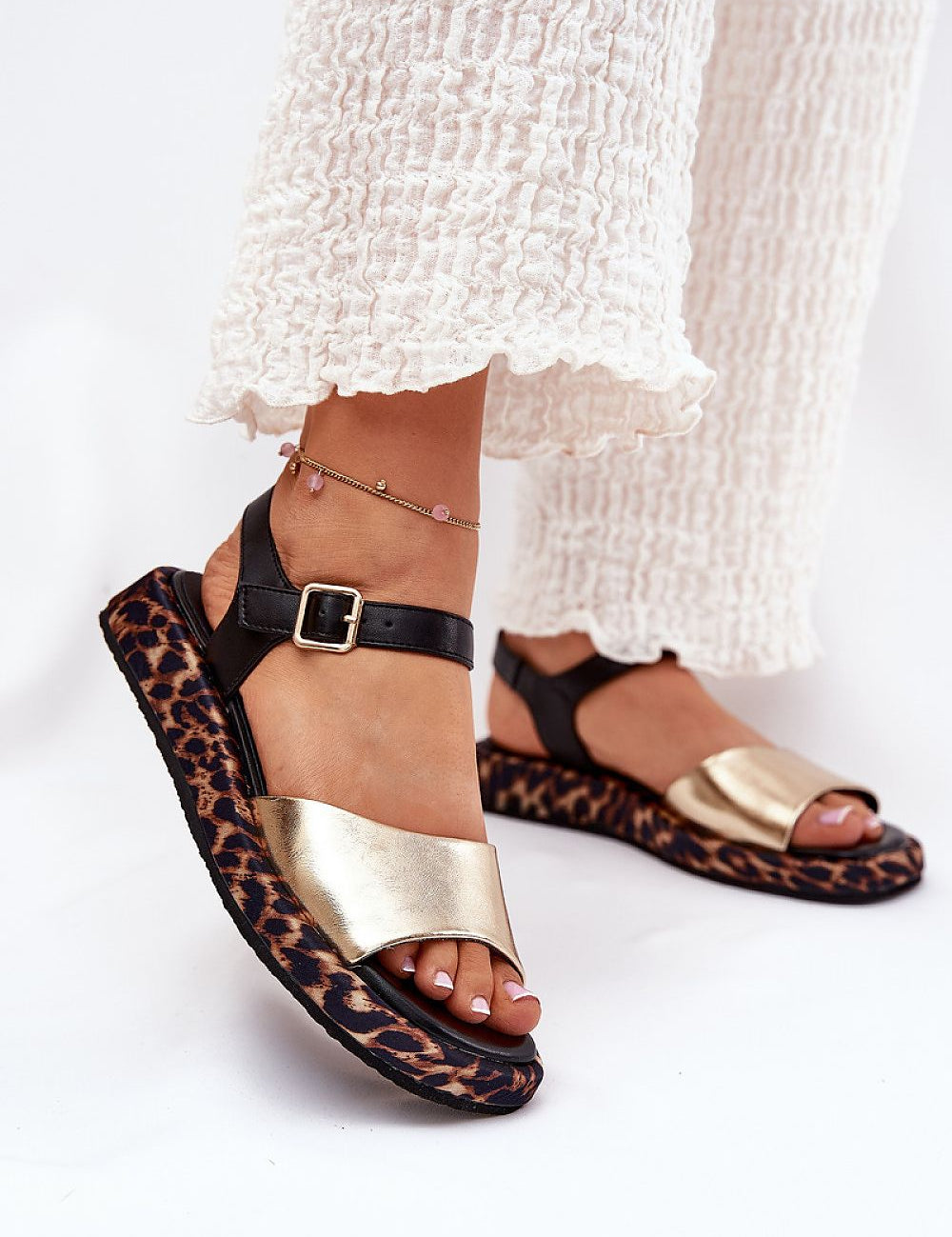Narivelle leather sandals with animal print platform and adjustable ankle strap, worn with white trousers.