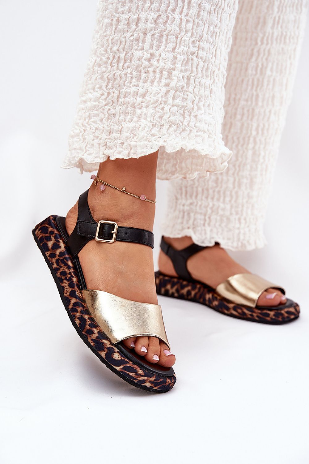 Narivelle leather sandals with animal print platform and adjustable ankle strap, worn with white trousers.