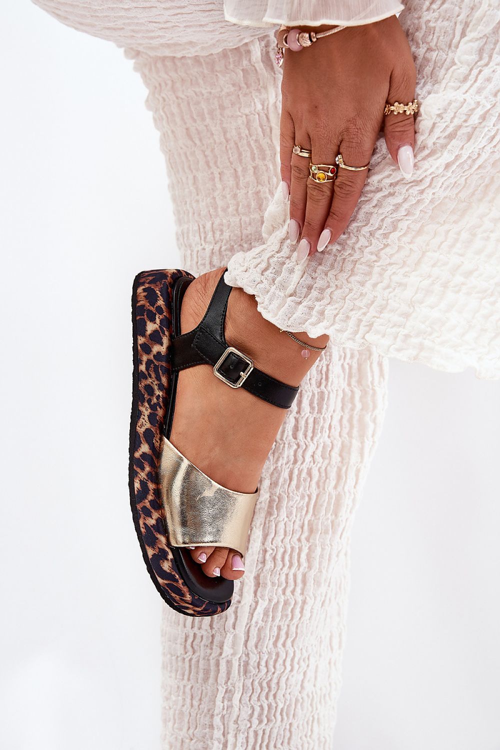 Narivelle leather sandals with animal print platform and adjustable ankle strap, worn with white textured pants.