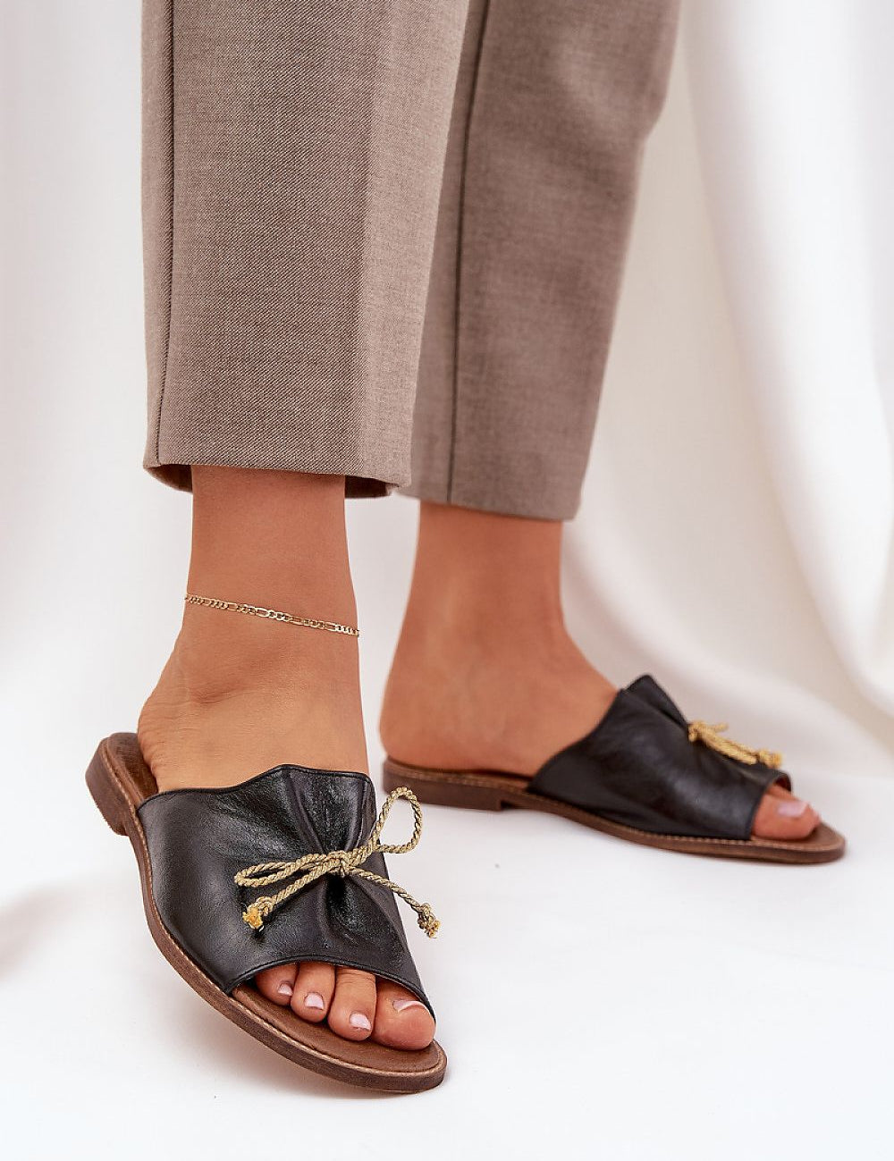Black Veletta Soft Bow Sandals with ruched leather upper and flat heel, perfect for summer outfits and casual elegance.