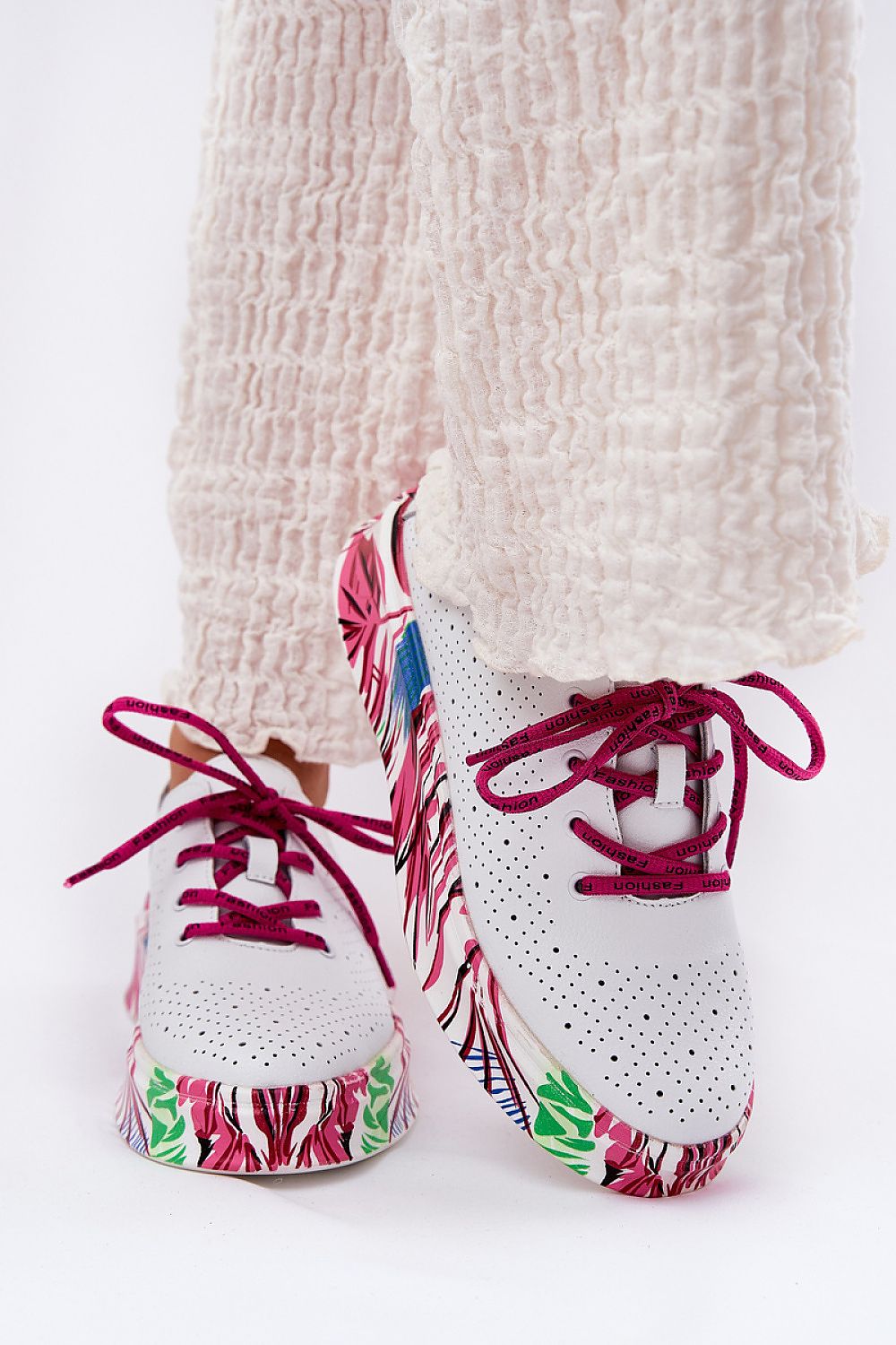 Lurevynn patterned platform sport shoes in white with colorful floral sole and red laces, worn with cream pants, showcasing versatility and style.