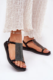 Woman wearing Cirellane Crystal Strap Sandals in black with imitation suede, showing crystal-adorned straps and adjustable buckle.