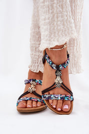 Woman wearing Aviretta Braided Zircon Sandals with braided straps, shimmering zircons, and floral decorations on a white background.