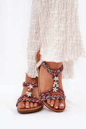 Woman wearing Zirellia Woven Flat Sandals with shimmering zircons and embellished straps, showcasing summer fashion.