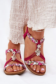 Elverina Braided Zircon Flat Sandals with pink straps and decorative flowers, worn by a model with white pants.