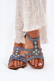 Elessa Woven Strap Sandals with blue braided straps and floral accents, worn with white flowy pants