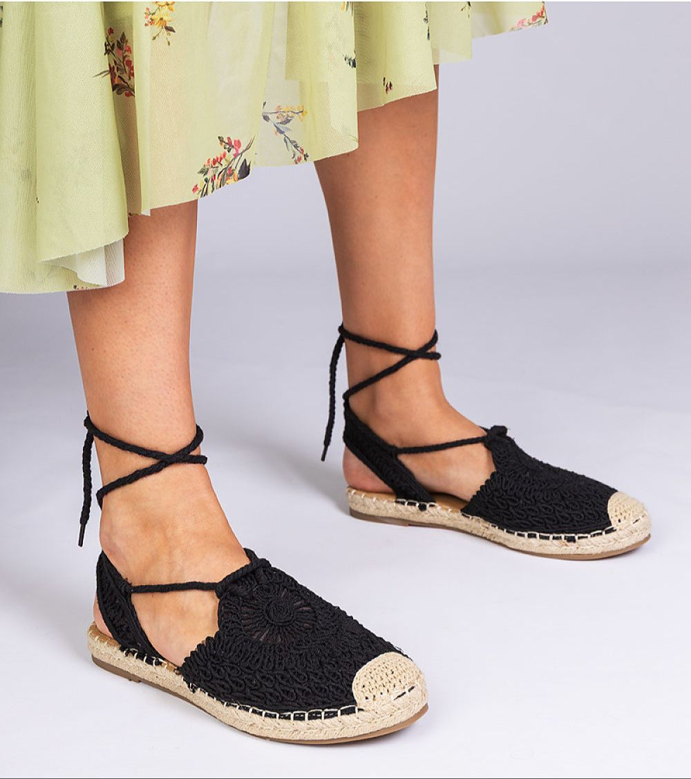 Woman wearing Serella espadrille sandals with braided jute sole and black textile, perfect for summer fashion.