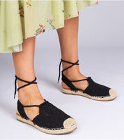 Woman wearing Serella espadrille sandals with braided jute sole and black textile, perfect for summer fashion.