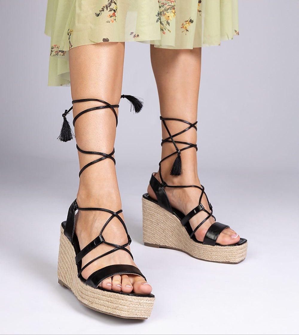 Nyrella high wedge espadrilles with black eco leather straps and braided jute wedge, ideal for garden parties.