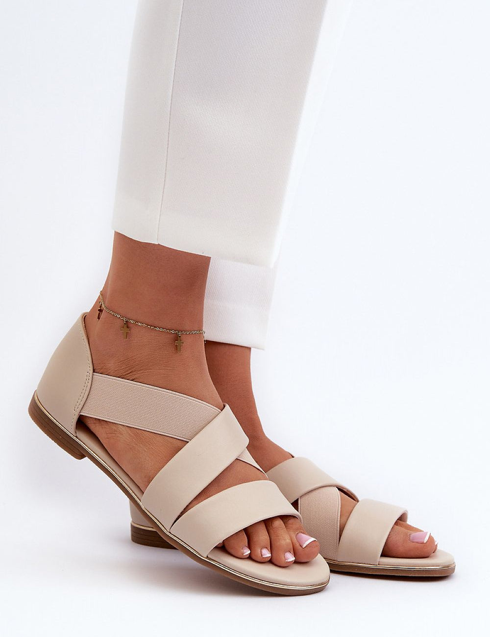 Model wearing Zirella Elastic Strap Sandals in beige eco-leather with elastic strap and soft insole, paired with white pants.
