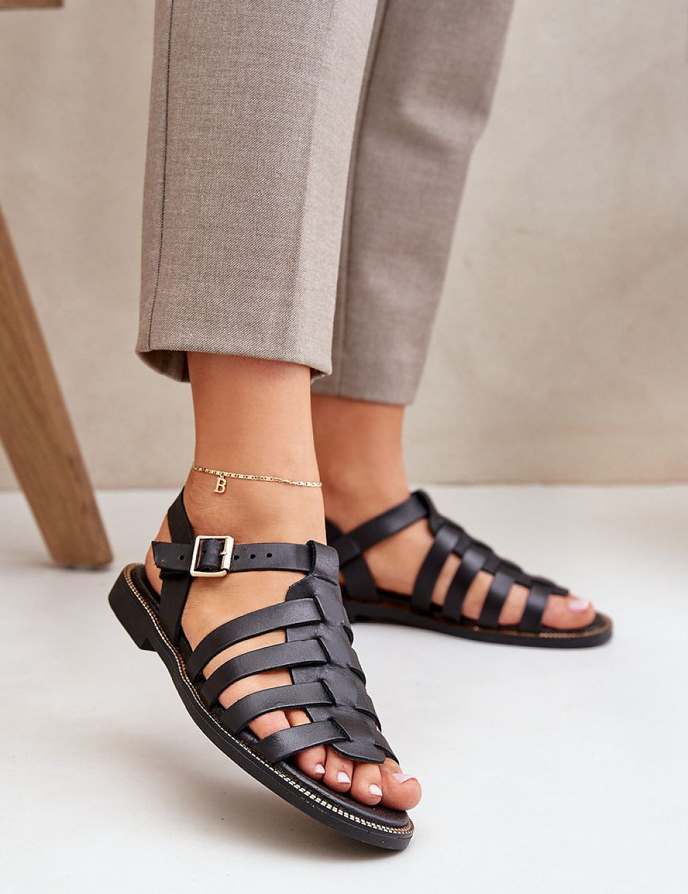 Women's Celira Flat Leather Sandals with ankle buckle, crafted from natural leather, showcasing sleek strap design for everyday elegance.
