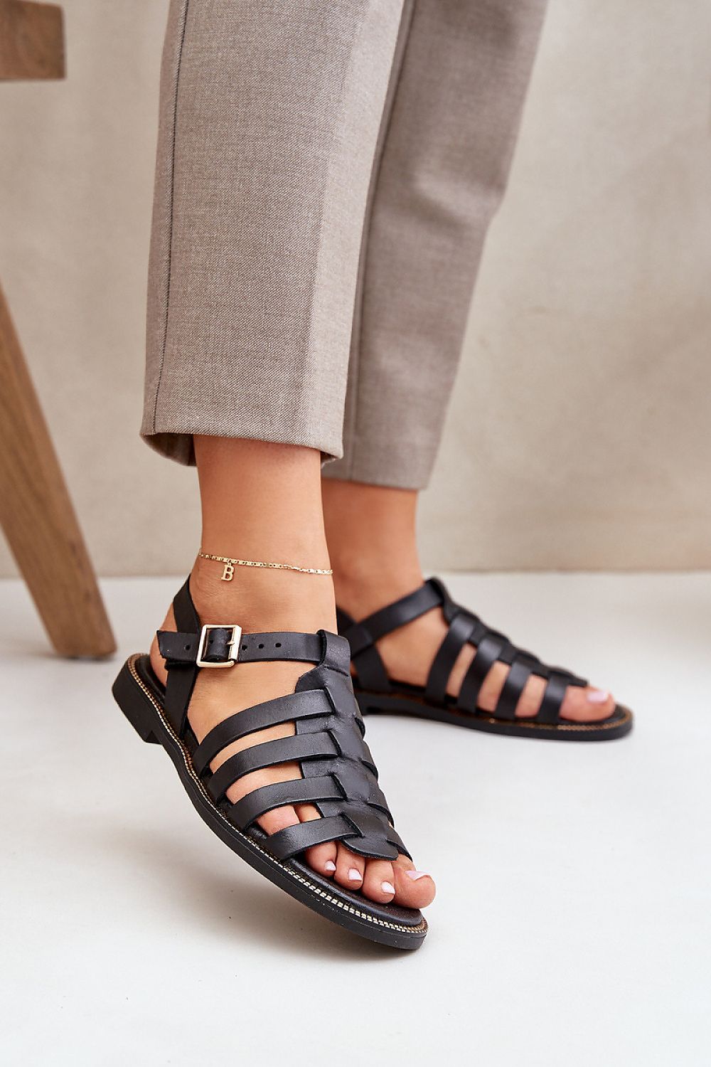 Women's Celira Flat Leather Sandals with ankle buckle, crafted from natural leather, showcasing sleek strap design for everyday elegance.