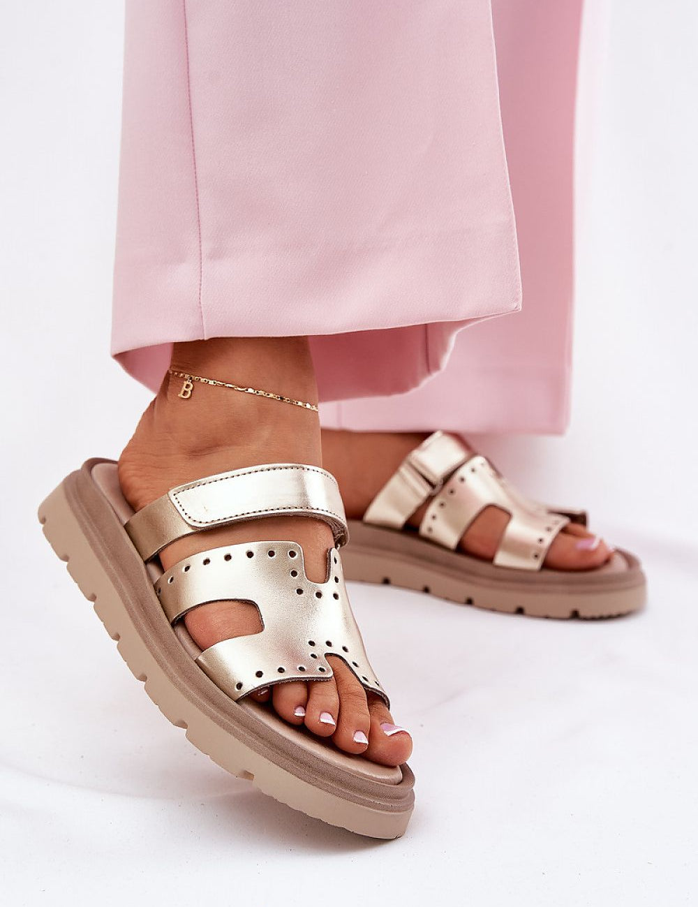 Woman wearing Mavena Platform Strap Sandals with wide upper strap and 3 cm platform sole, paired with pink pants.