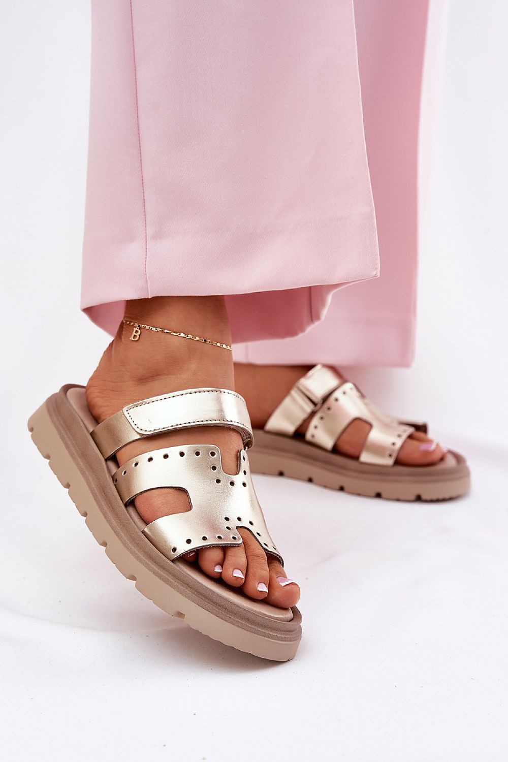 Woman wearing Mavena Platform Strap Sandals with wide upper strap and 3 cm platform sole, paired with pink pants.