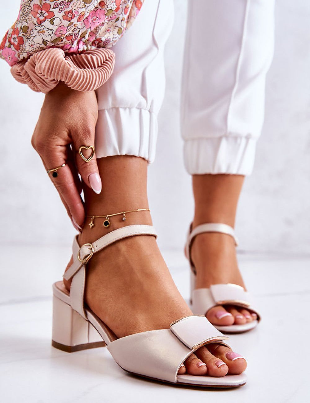 Ernara heel-strap sandals with eco leather, decorative front accent, and low heel, worn on foot with stylish pants and bracelets.