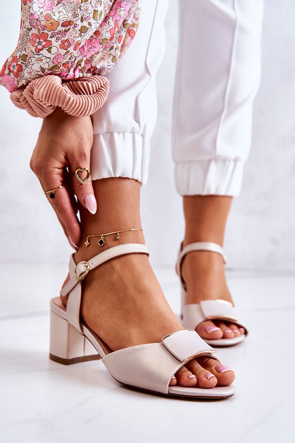 Ernara heel-strap sandals with eco leather, decorative front accent, and low heel, worn on foot with stylish pants and bracelets.