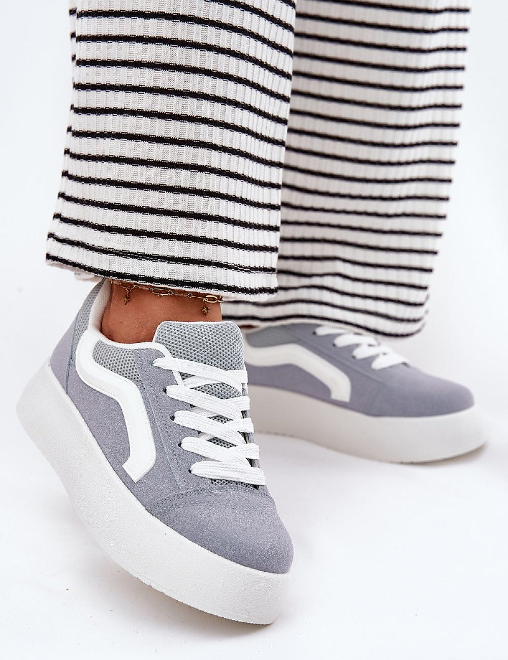Ravelin Suede Platform Sneakers crafted from eco-suede with a rounded toe and supportive sole, styled with striped trousers.