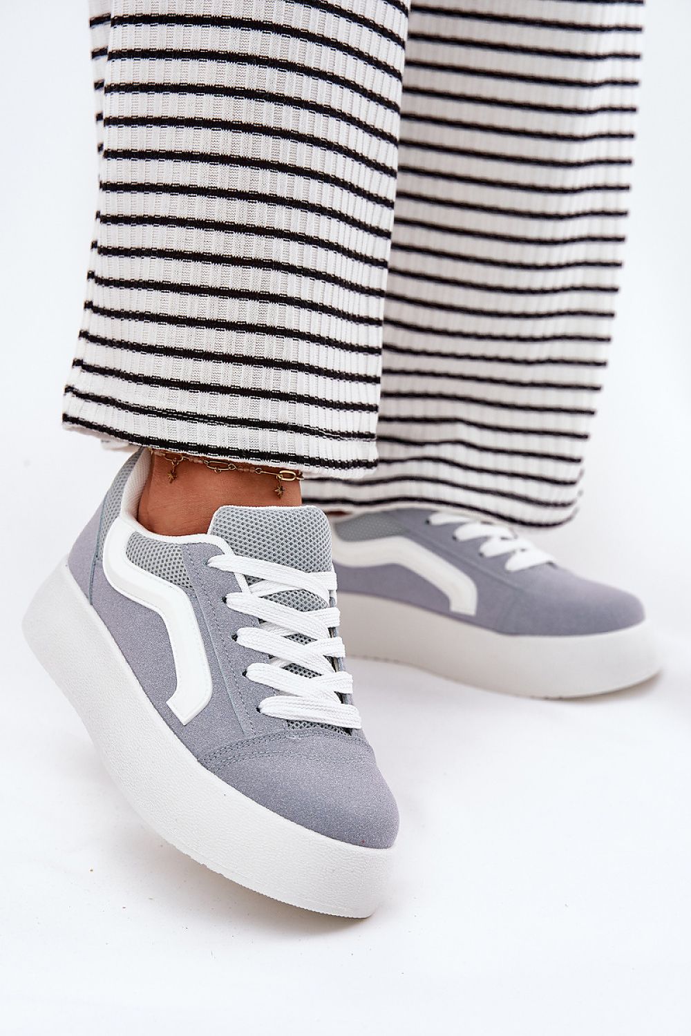 Ravelin Suede Platform Sneakers crafted from eco-suede with a rounded toe and supportive sole, styled with striped trousers.