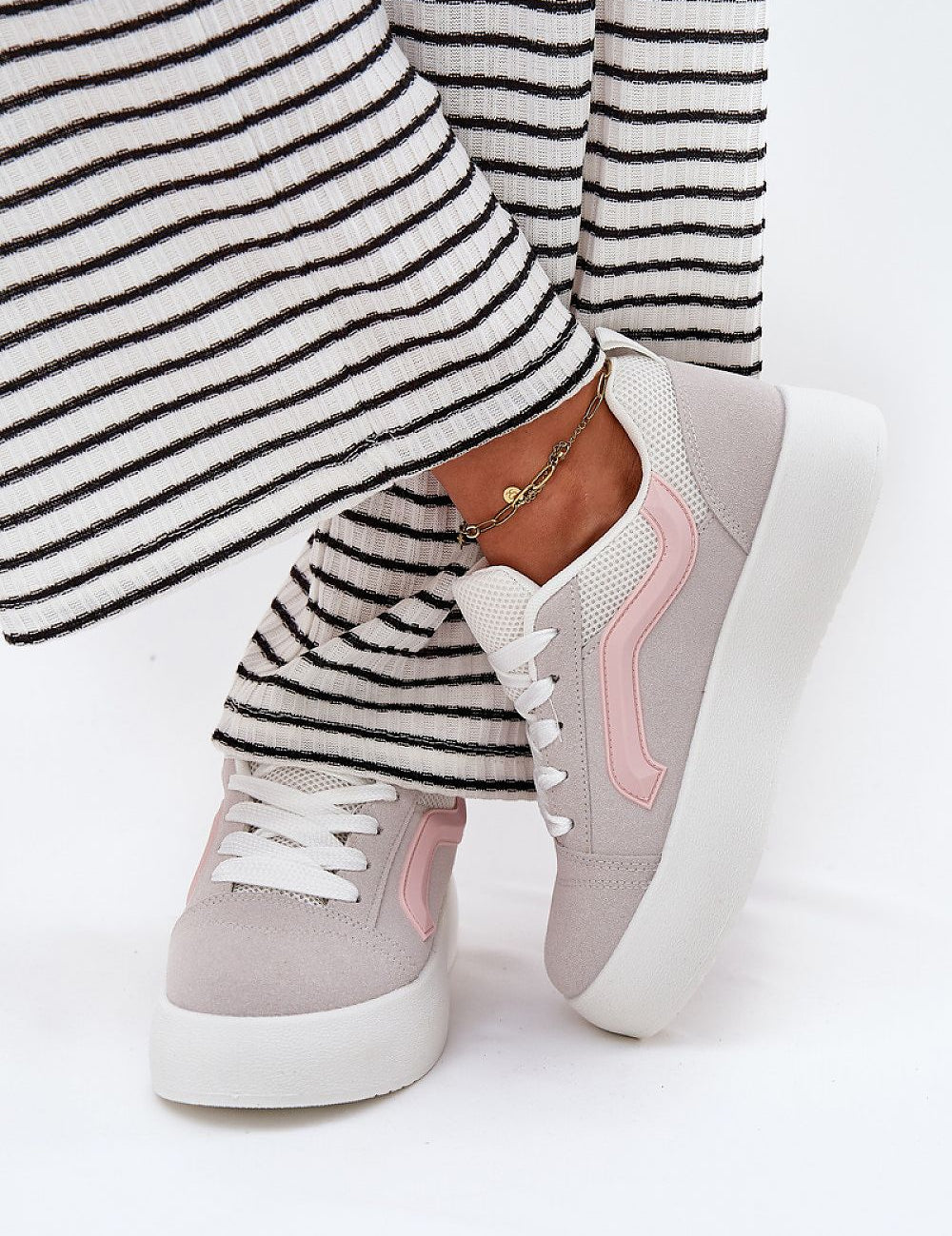 Ravelin suede platform sneakers with a pink stripe, worn with striped trousers, featuring eco-suede and supportive sole.