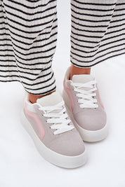 Woman wearing Ravelin suede platform sneakers with soft eco-suede and a supportive sole, styled with striped trousers for a chic look.