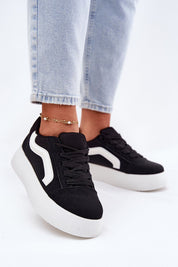 Ravelin Suede Platform Sneakers in black eco-suede with white accents, worn with light denim jeans, showcasing their rounded toe and platform sole.