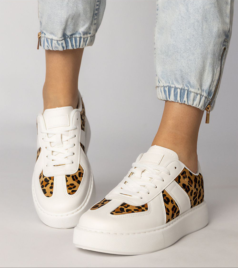 Tirella patterned platform sneakers with white-on-panther motif, synthetic leather, lace-up closure, shown on feet with jeans.