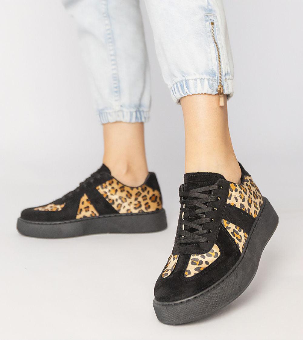 Person wearing Tirella Patterned Platform Sneakers with panther motif and platform sole, showcasing trendy style and comfort.