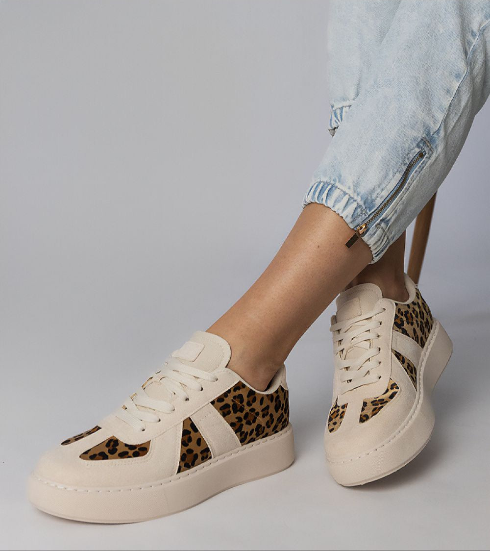 Stylish Tirella patterned platform sneakers with white-on-panther motif and smooth synthetic leather design, worn with casual denim.