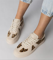White Tirella patterned platform sneakers with panther motif on feet, showcasing bold design and comfortable synthetic leather.