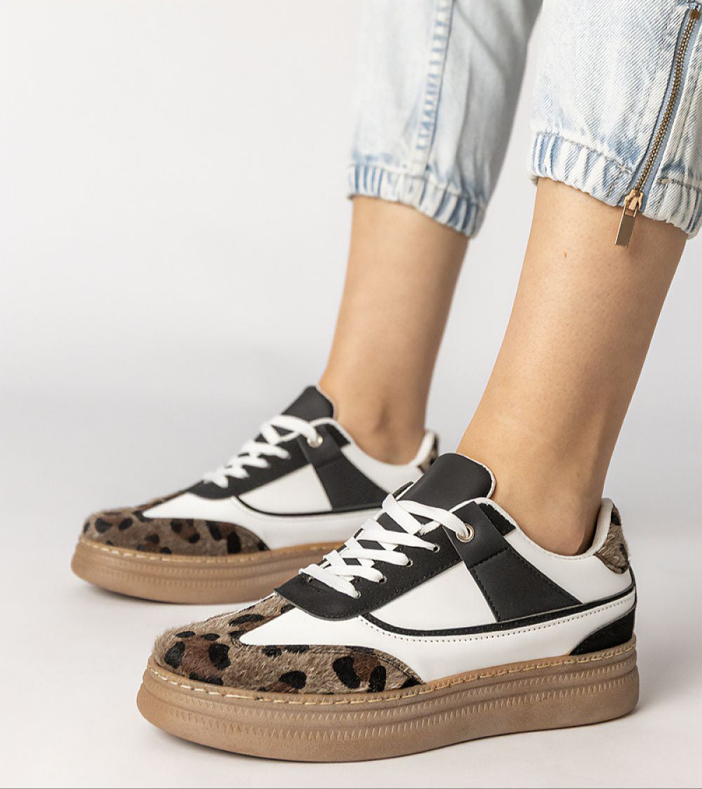 Woman wearing Merisse Panther Accent Sneakers, featuring white design with panther print detail and heightened platform.