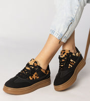 Woman wearing Merisse Panther Accent Sneakers with panther print detail and platform sole.