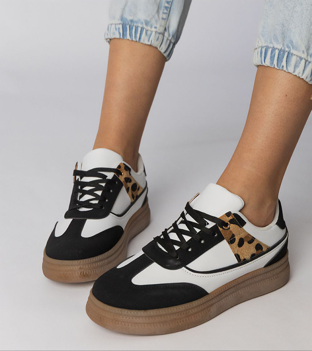 Person wearing Merisse Panther Accent Sneakers with white base and panther print detail