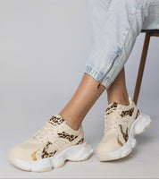 Woman wearing Thareen Platform Trainers with animal print, featuring chunky sole and faux leather finish for urban style.
