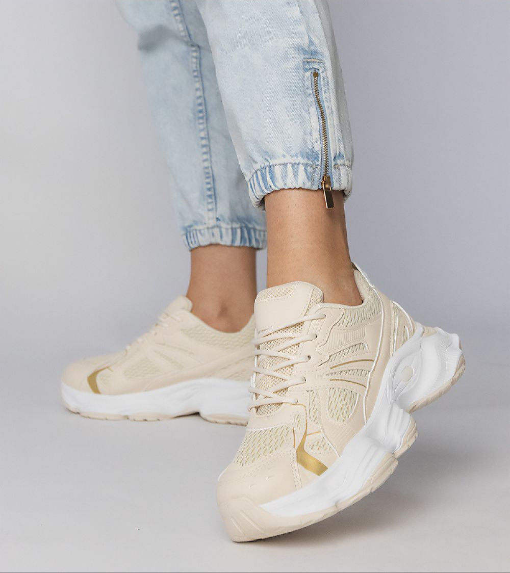 Person wearing Thareen Platform Trainers in beige with chunky sole and textured faux leather, showcasing casual urban style.