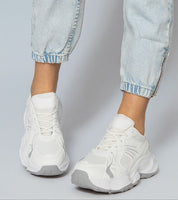 White Thareen Platform Trainers on feet with chunky sole and faux leather, perfect for urban style and everyday comfort.