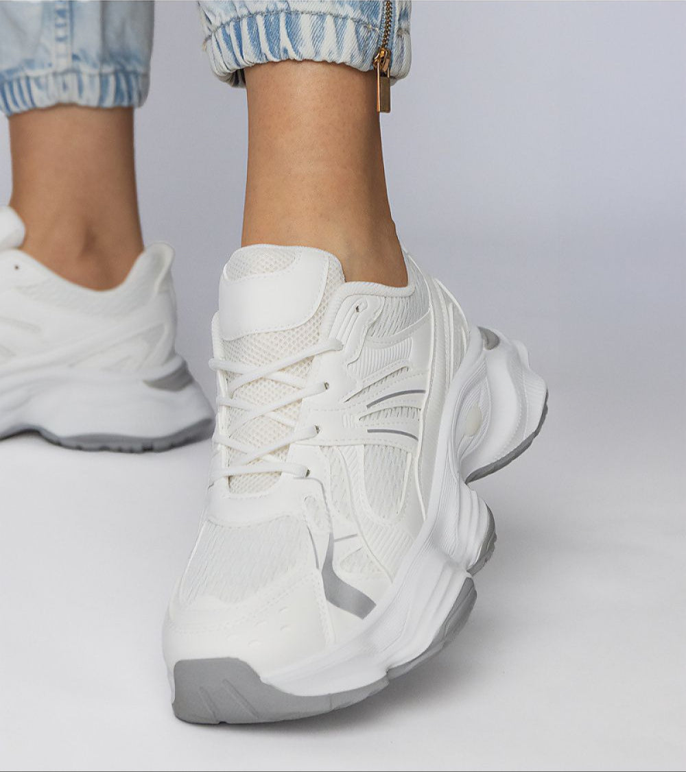 Person wearing white Thareen Platform Trainers with chunky sole and faux leather finish.