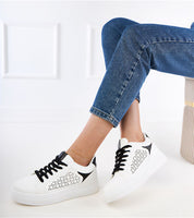 Person wearing Alnora Urban Platform Sneakers with subtle blue accents and eco leather, ideal for dynamic city life.