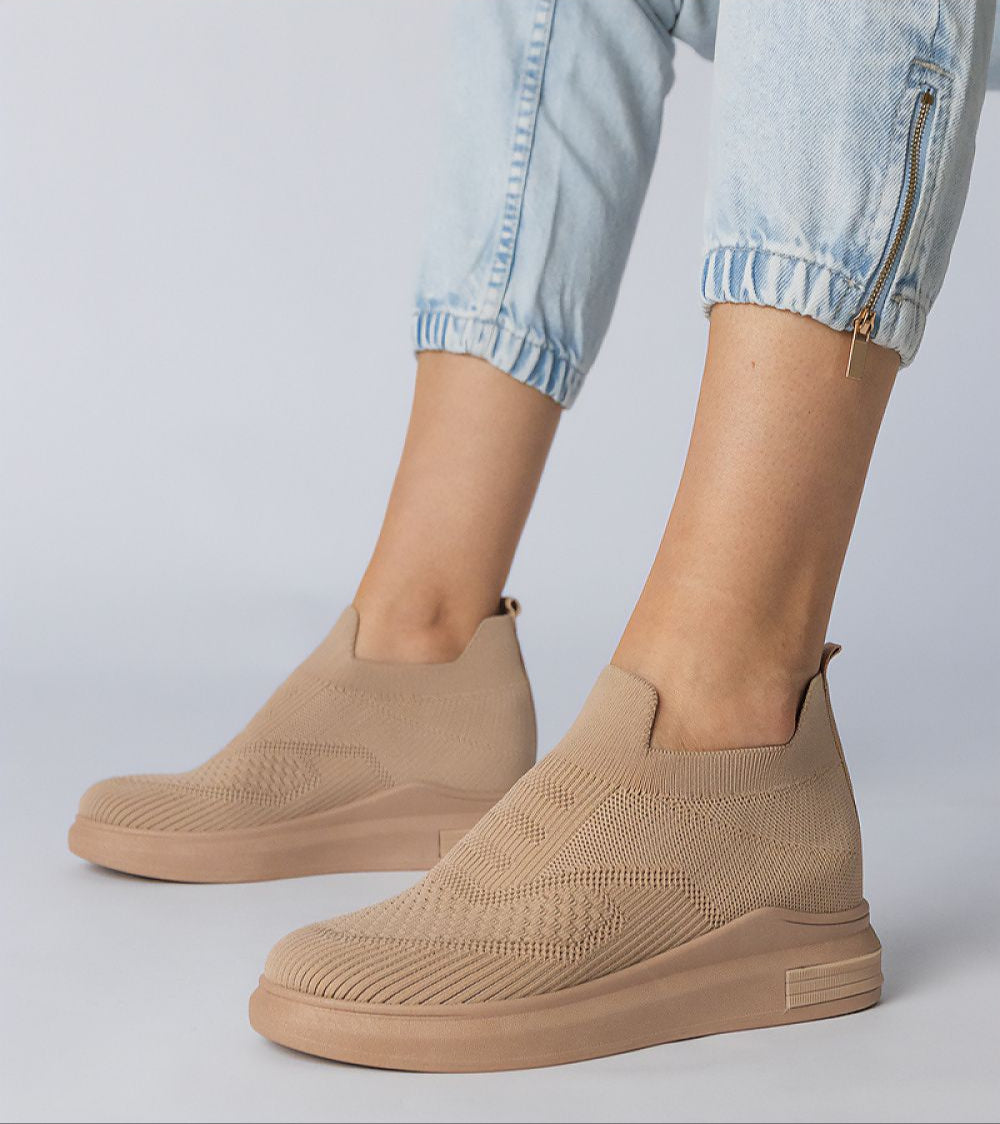 Beige Shadowknit slip-on sock sneakers with flexible stretch-knit upper and firm platform sole, styled with casual jeans.