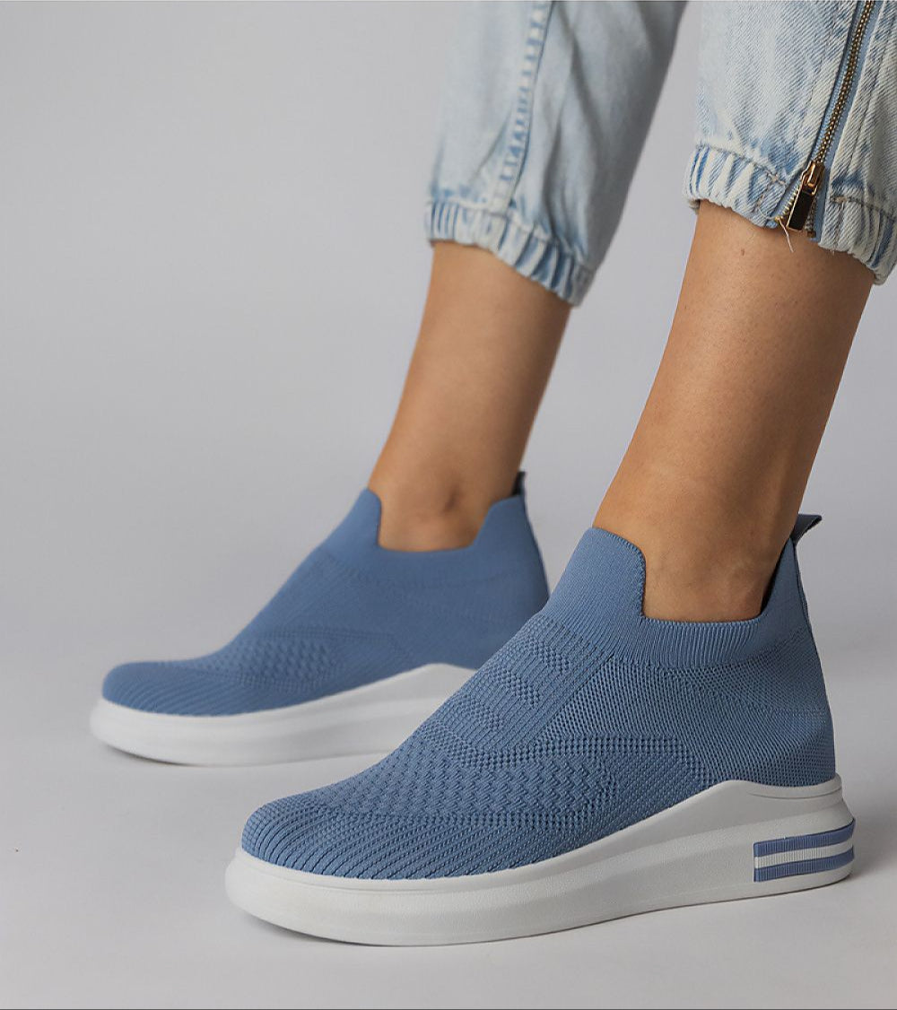 Blue Shadowknit slip-on sock sneakers with a flexible stretch-knit upper and white platform sole, perfect for urban casual outfits.