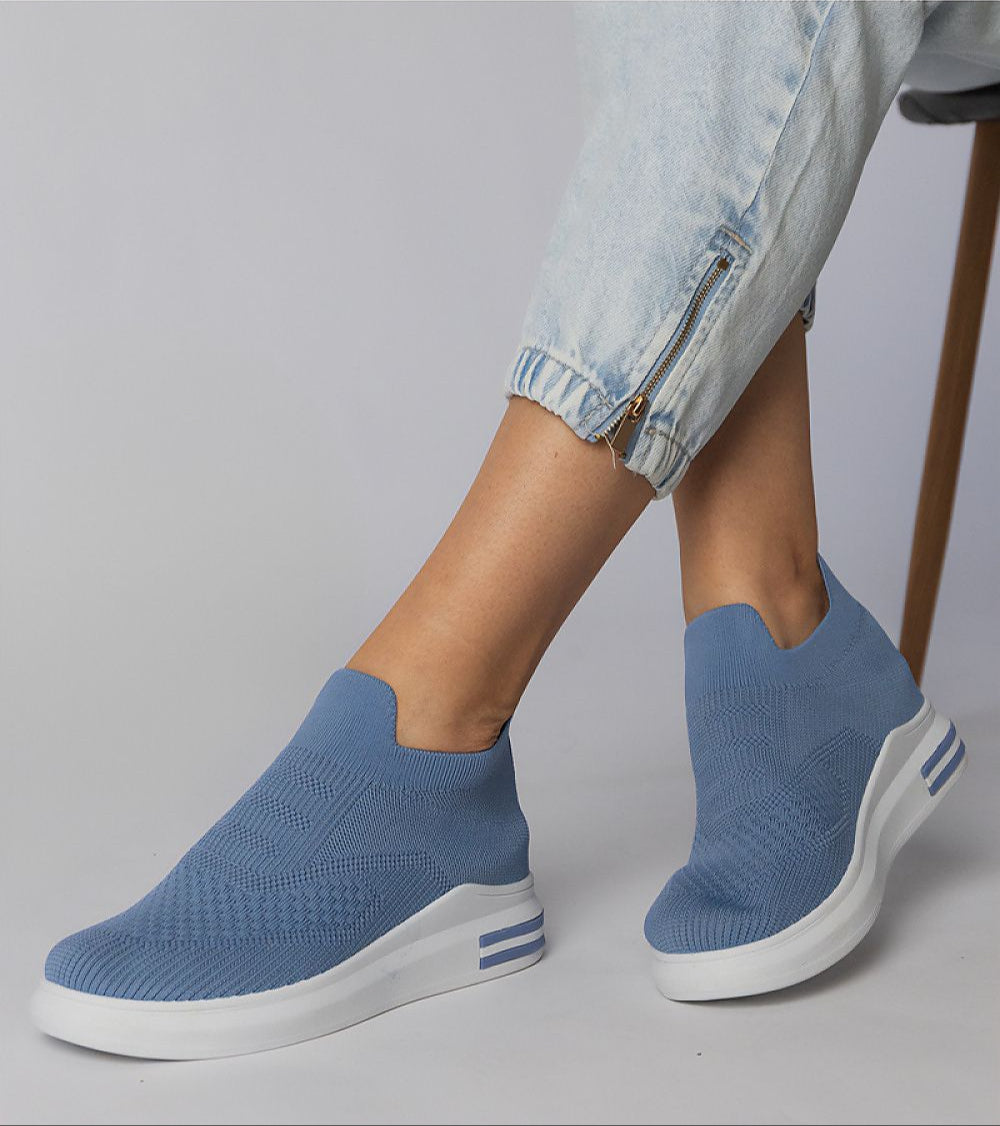 Blue slip-on sock sneakers with a flexible stretch-knit upper and platform sole, offering a minimalist look and urban edge.