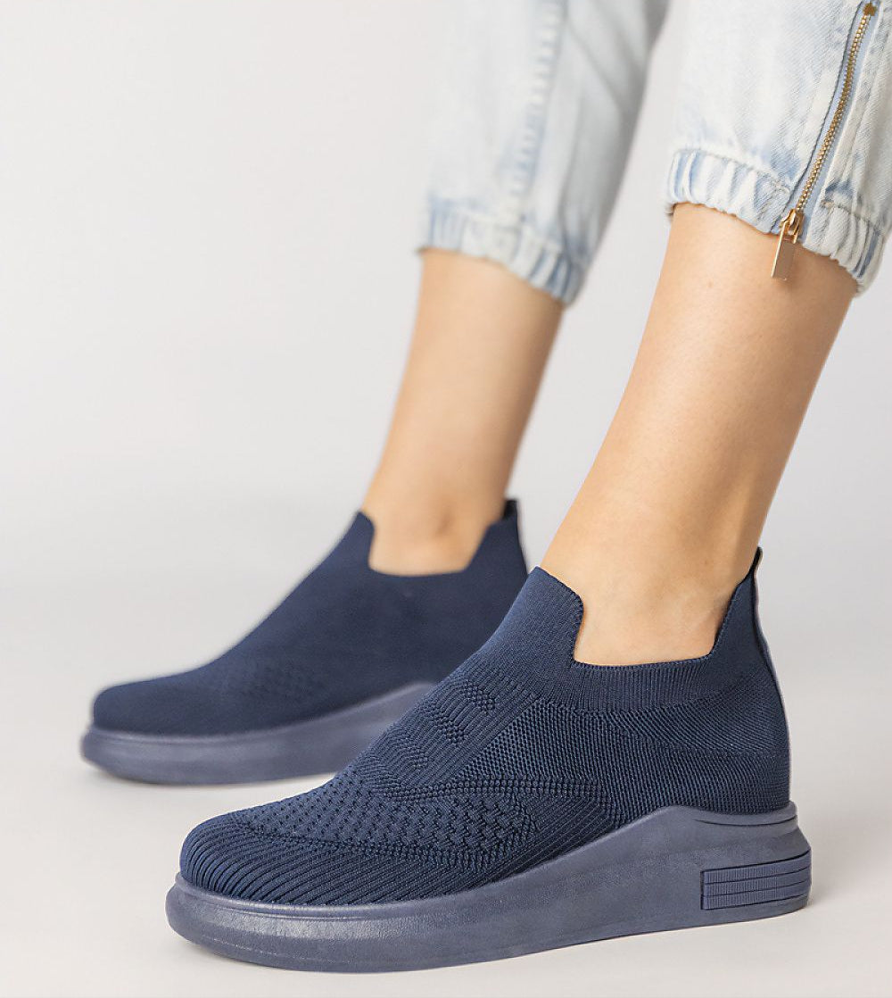 Navy blue Shadowknit Slip-On Sock Sneakers with stretch-knit upper and platform sole, styled with rolled-up jeans.
