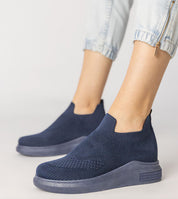 Navy blue Shadowknit Slip-On Sock Sneakers with stretch-knit upper and platform sole, styled with rolled-up jeans.