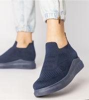 Navy Shadowknit Slip-On Sock Sneakers with flexible stretch-knit upper and platform sole, styled with light jeans, showing urban chic look.