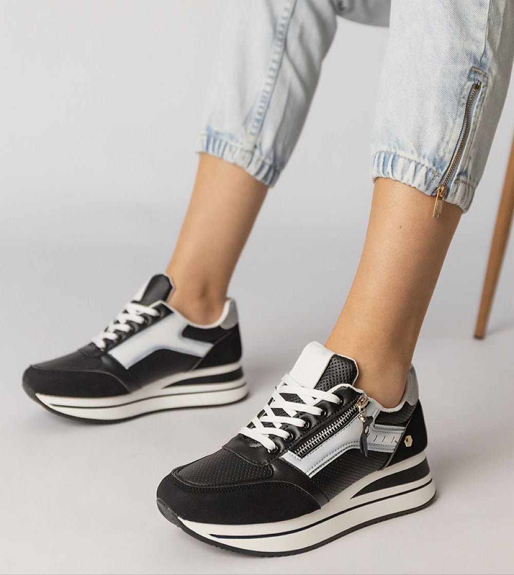 Black Vorelle Zip-Up Sneakers with side zipper and platform design, worn with light denim pants, showcasing sporty casual style.
