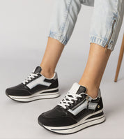 Black Vorelle Zip-Up Sneakers with side zipper and platform design, worn with light denim pants, showcasing sporty casual style.